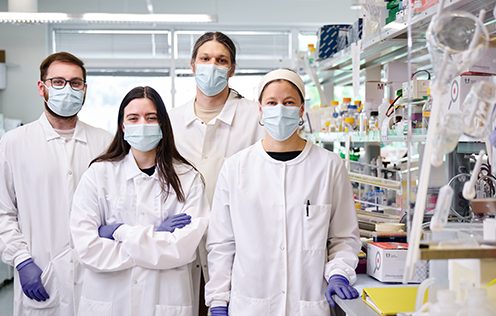 A group of people in lab coats posing for a photo.
